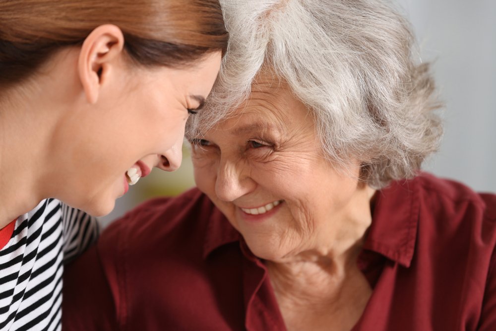 Senior woman with her caregiver smiling and looking at each other