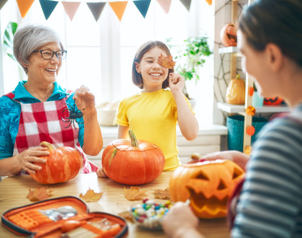 Grandmother and grandchildren carving pumpkins together