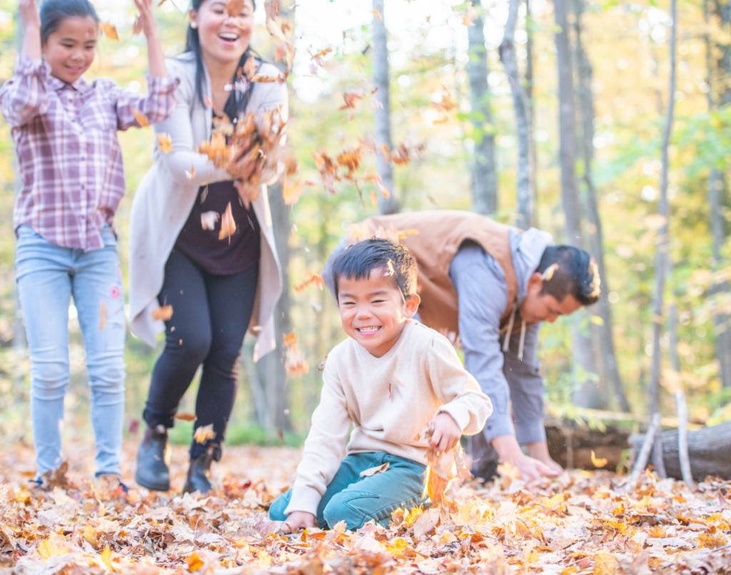 Happy, healthy family enjoys fall leaves in the outdoors