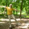 Senior woman doing balance exercises in the park.