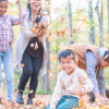 family playing in a pile of leaves.