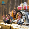 Overjoyed mother father and little daughter look out from window of car with Christmas presents on roof waving hands.